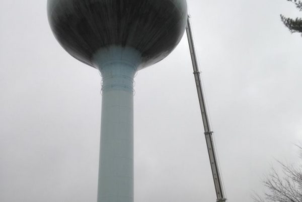 Using our crane with offset jib setting cell antennas on top of water tower.