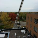 Crane from the roof. The lower roof and the upper peaked roof were the biggest obstacles. On the high roof there were cell phone antennas sticking up about an extra 10 ft. in the air.