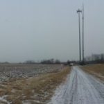 Panorama of the crane set up in the middle of a large field.