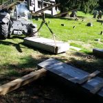 We are going to pick the gravestone flat and get it over near the base and then slowly stand it up by rendering the strap to the top and raising the forklift and letting the gravestone slide on its bottom to find center and then set it.