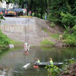 Setting barriers in the water to support the first truss.